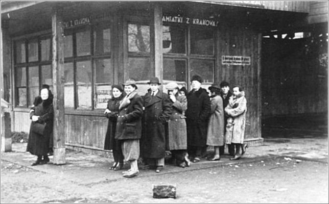Jews wait in line on a streetcorner in the Krakow ghetto
